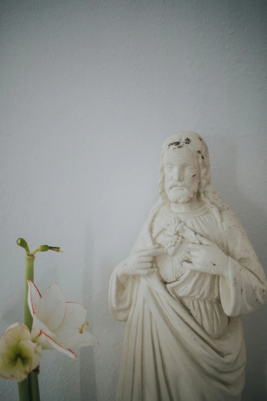 a statue stands next to a flower that appears to have been placed in front of it