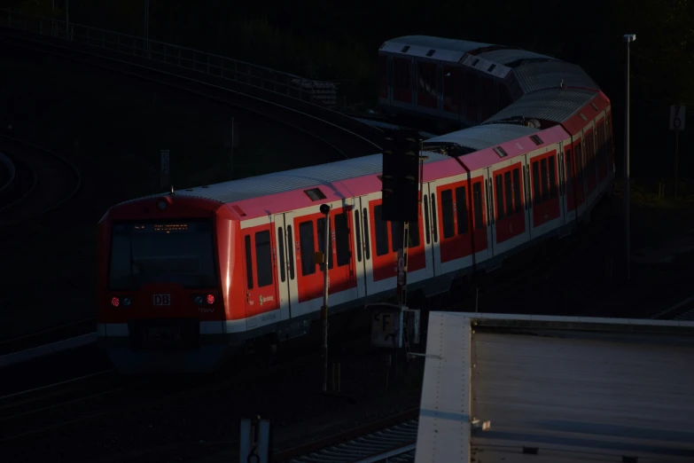 red subway train passing through on the track