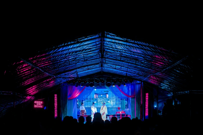 a group of people are standing under a tent