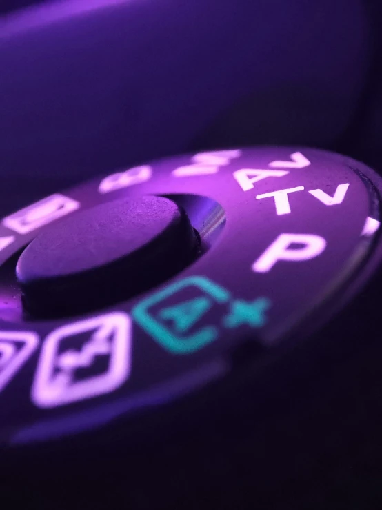 a purple controller with icons lit up by neon