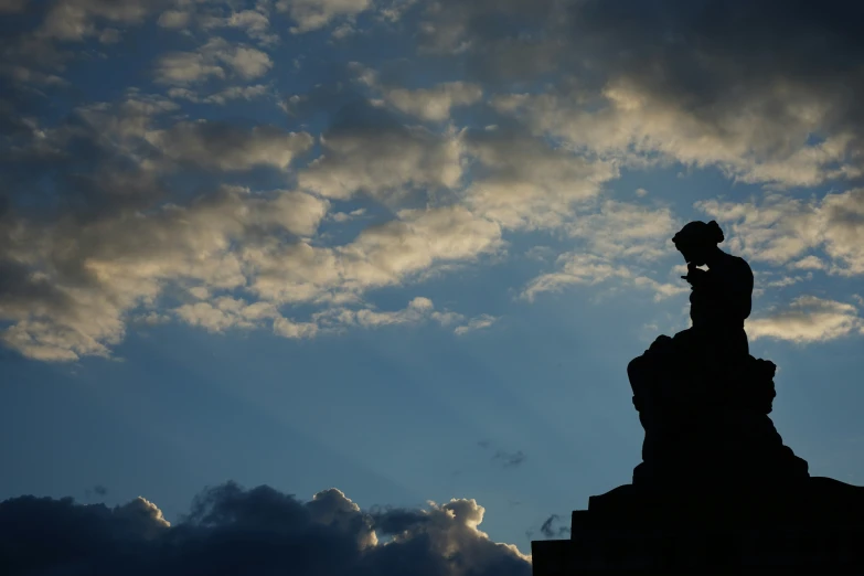 a silhouette of a person on top of a rock