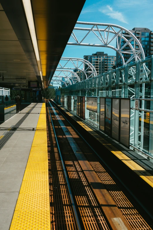 train tracks near a subway platform with a bridge above them