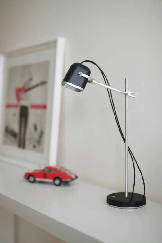 a lamp sitting on top of a table next to a small car