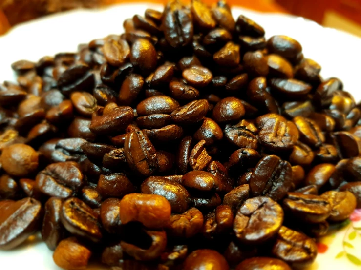 a pile of coffee beans sitting on top of a white plate