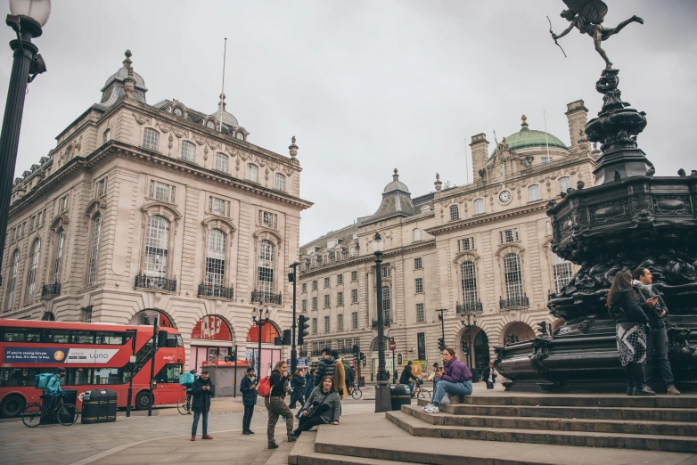 people are walking around outside a city with tall buildings