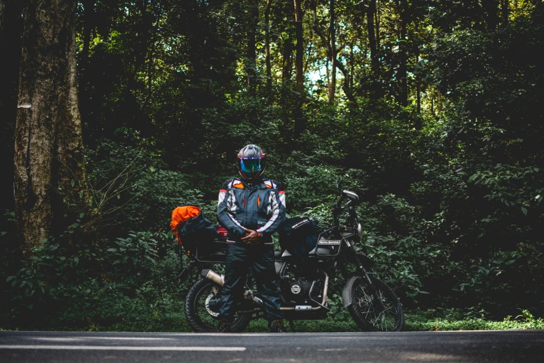 a couple on a motorbike standing in the middle of a road