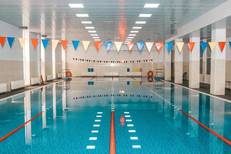 a long pool with a line of flags above the blue water