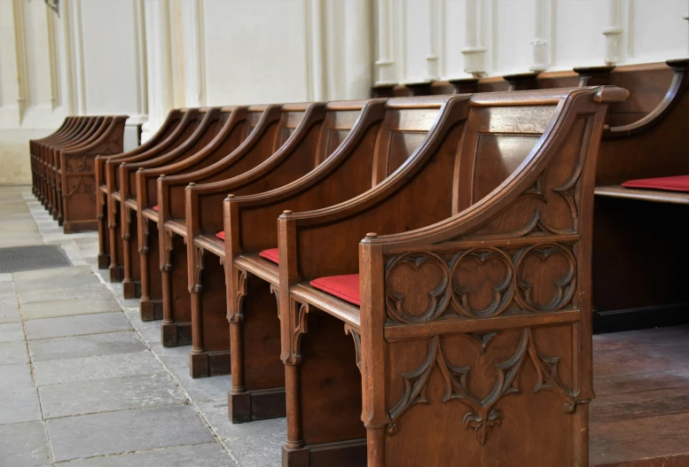 a line of wooden benches in a room