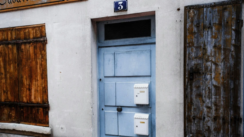 a large blue door is near a white building