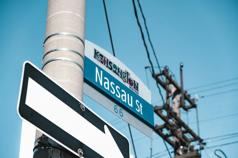 two signs on top of a street post next to power lines