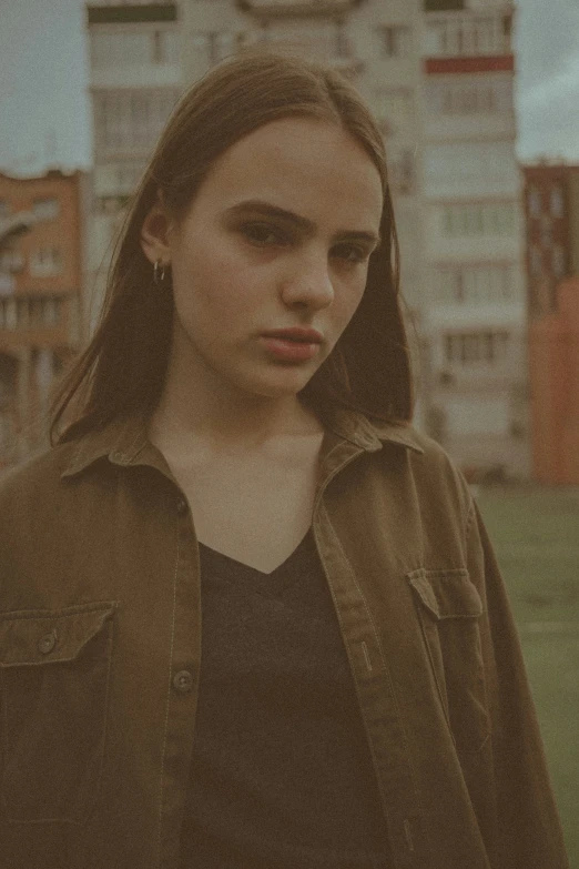 a woman wearing dark clothes standing on a grassy field