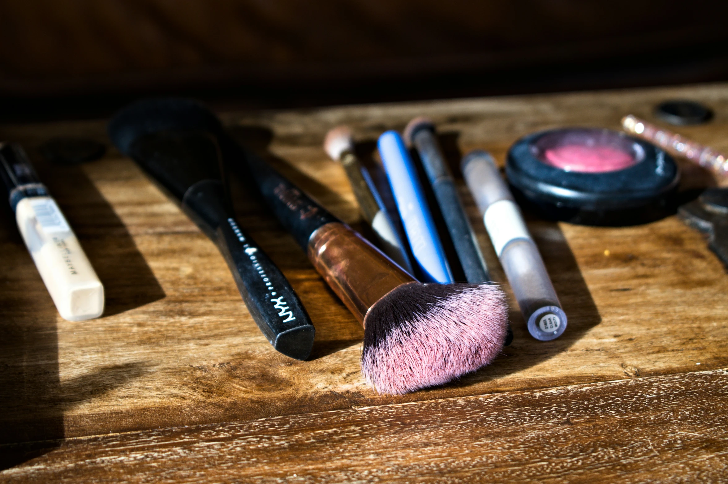 various cosmetics is on the table and next to it's brushes