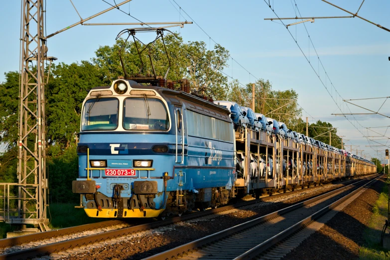 an image of a blue train going down the tracks