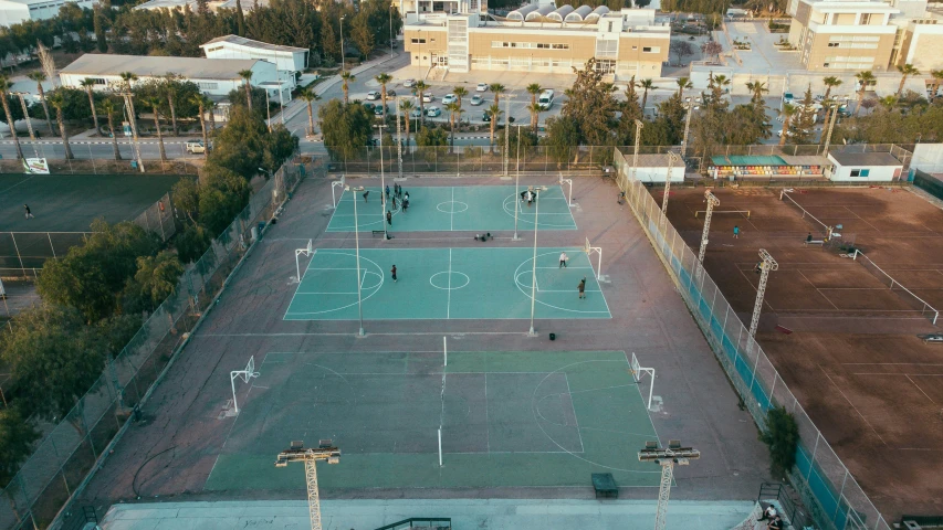 tennis court in middle of city surrounded by houses