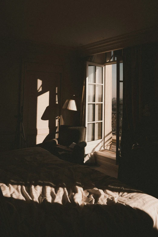 a dark bedroom with sunlight shining in through the window