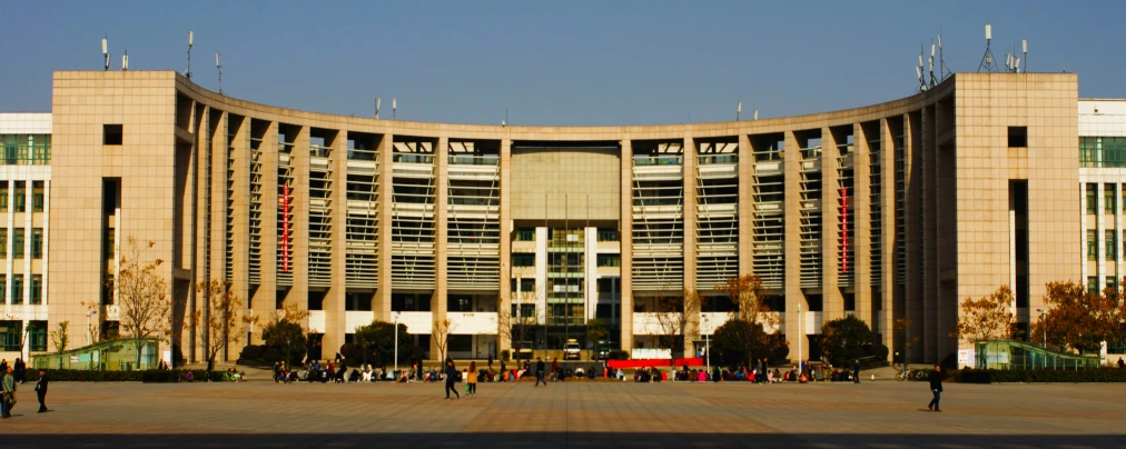 several people walking near the outside of a large building