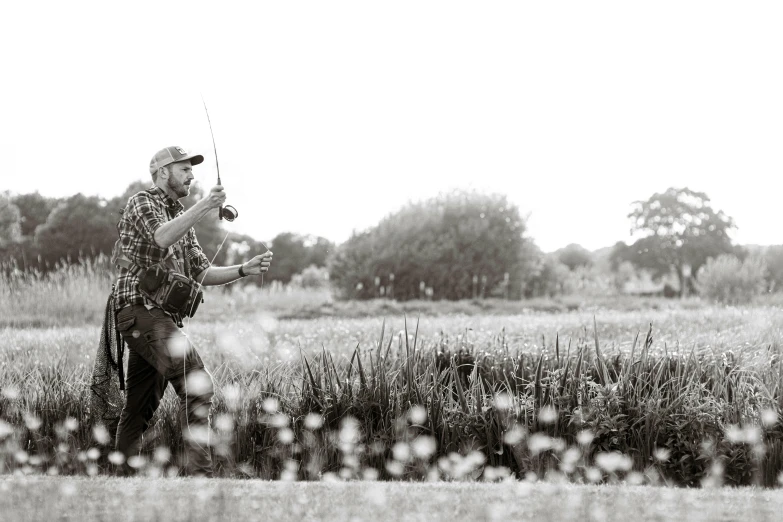 a man stands in a field while holding his golf club