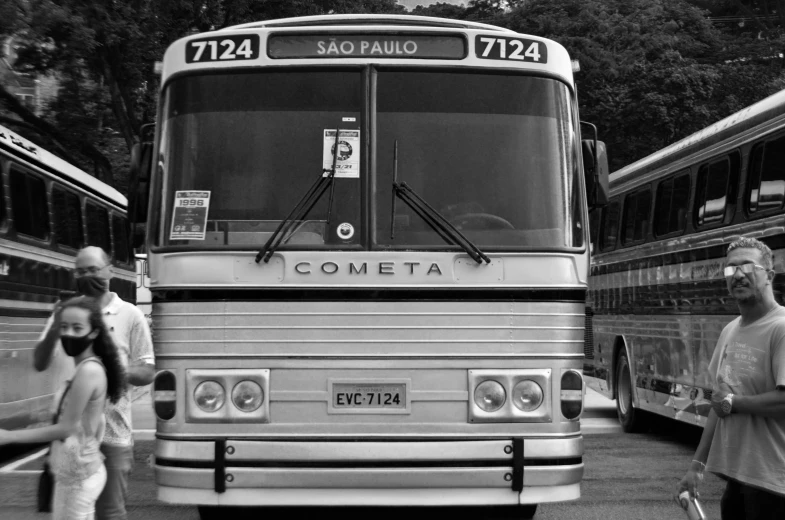 a black and white po of people by some buses