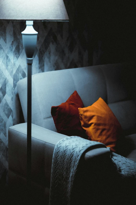 a white couch sitting in front of a lamp