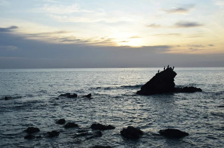 a beach covered in rock in the ocean