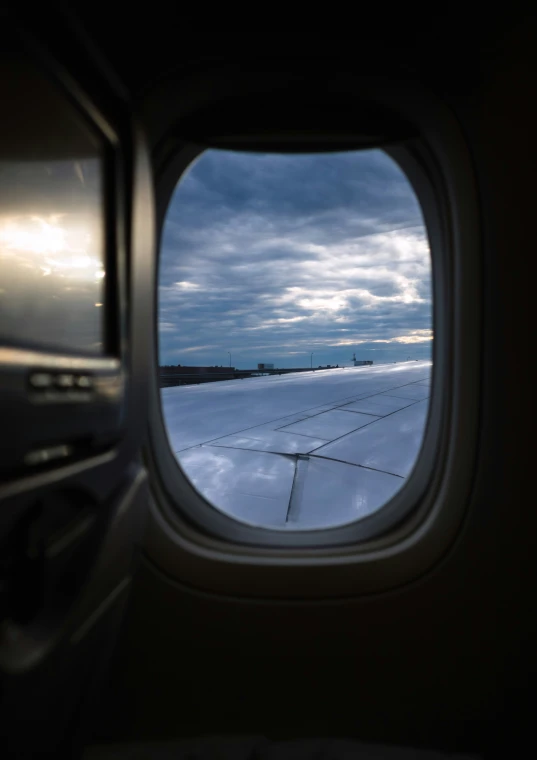 the view out an airplane window shows the snowy ground and snow - capped mountain