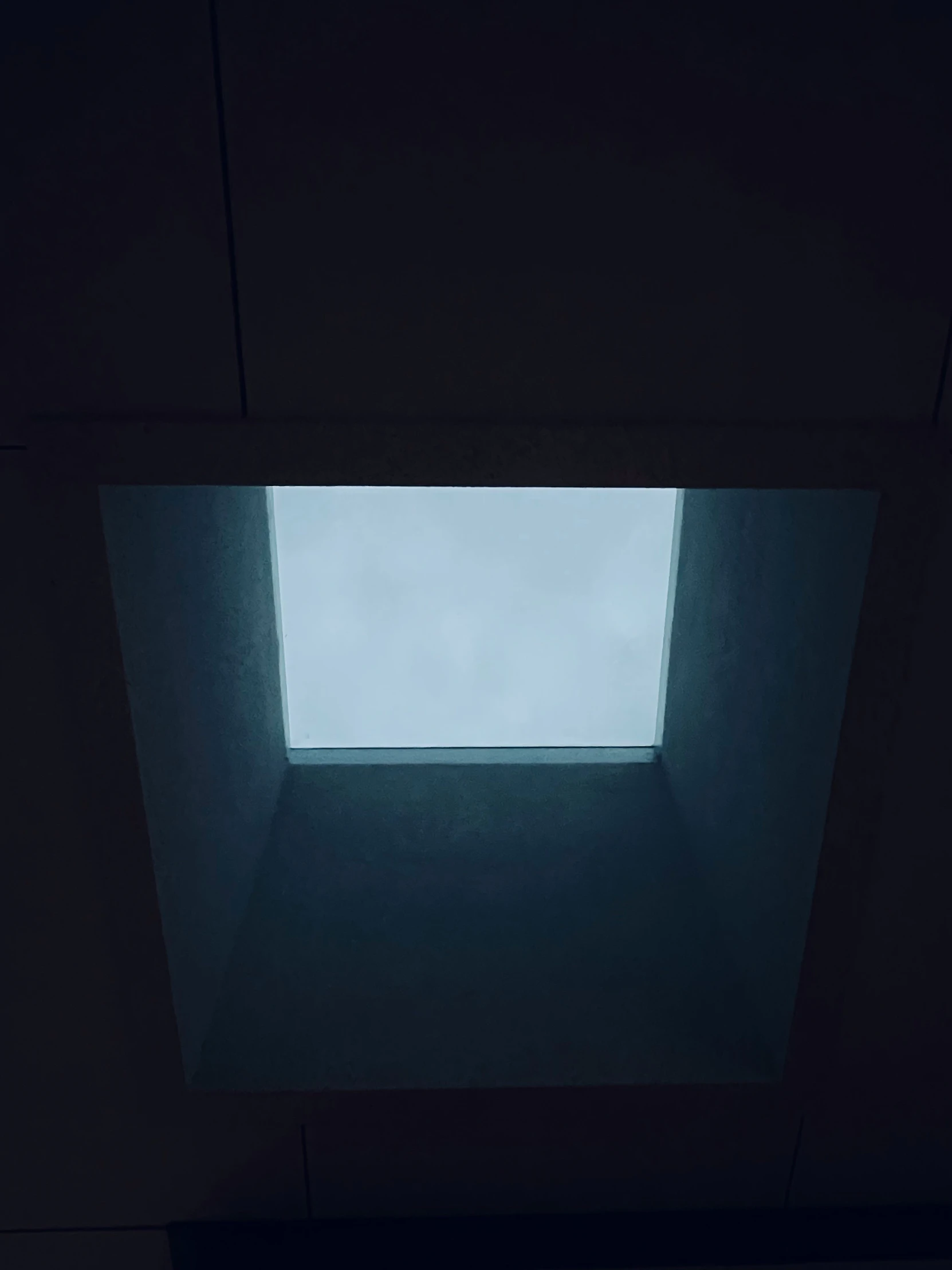 a view of the skylight through a dark room