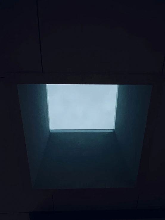 a view of the skylight through a dark room
