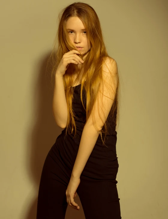 a young woman wearing all black poses in a studio po