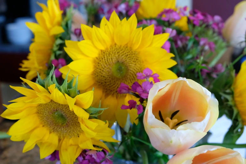 the sunflowers and other colorful flowers are in a vase