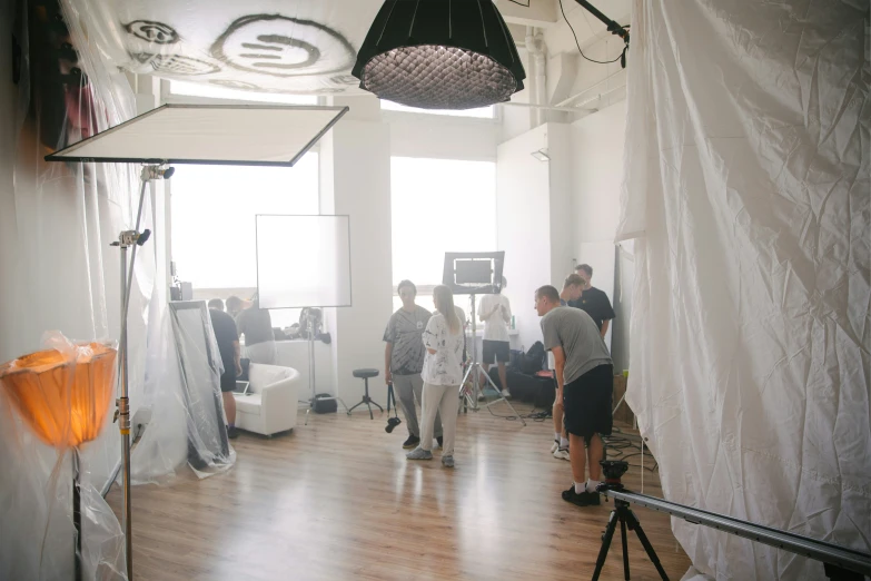 several people standing in a room with one woman taking pictures