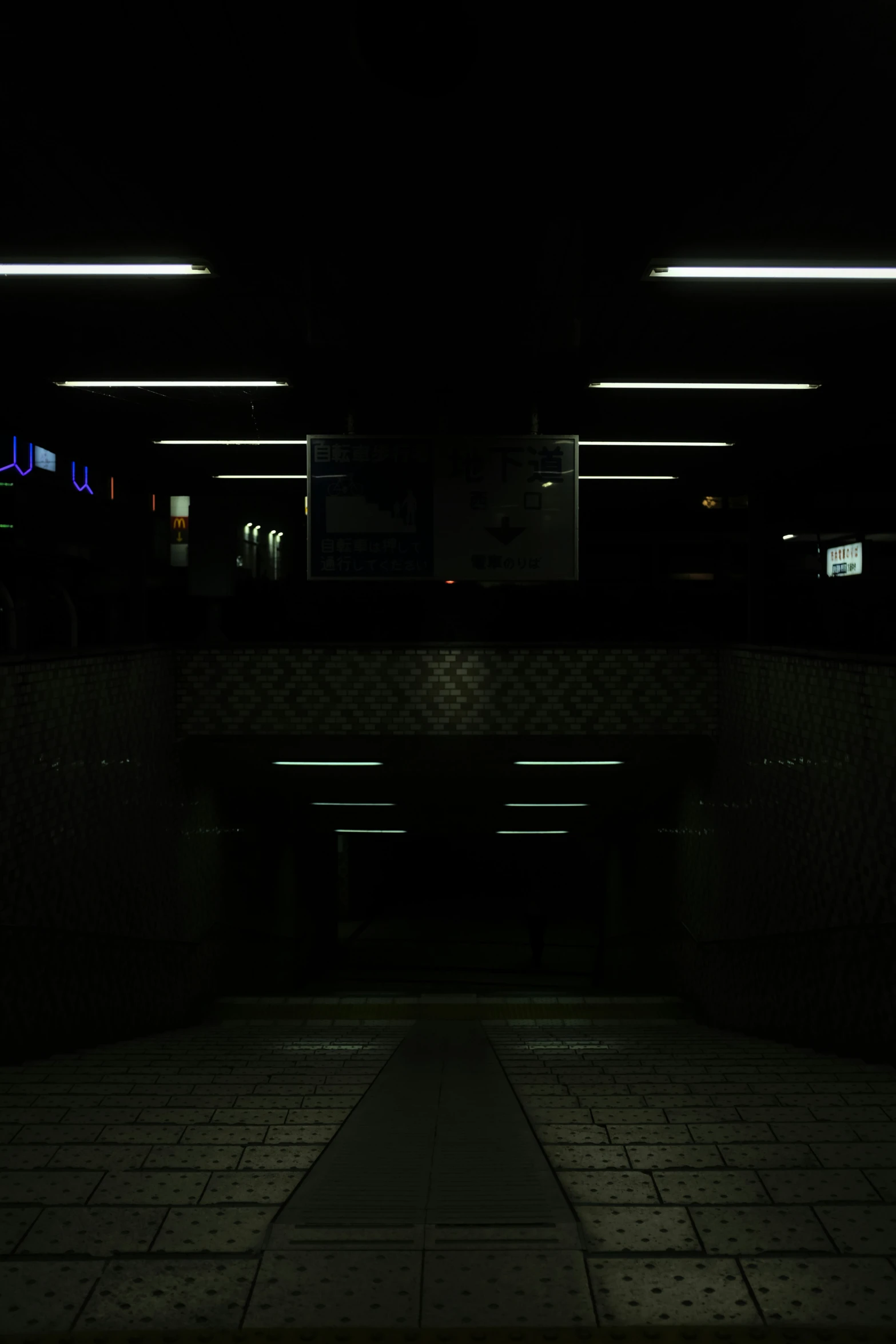 a street sign lit up at night with the dark on