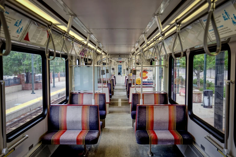 an empty subway car is pictured with colorful seats