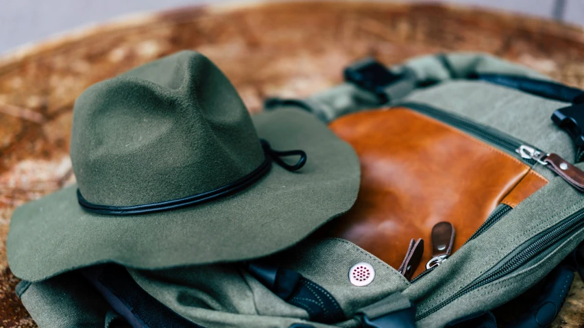 a backpack with a hat on top and glasses laying on top