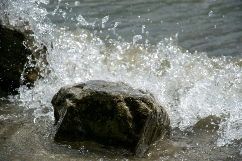 the water splashes over a rock in the middle of the river