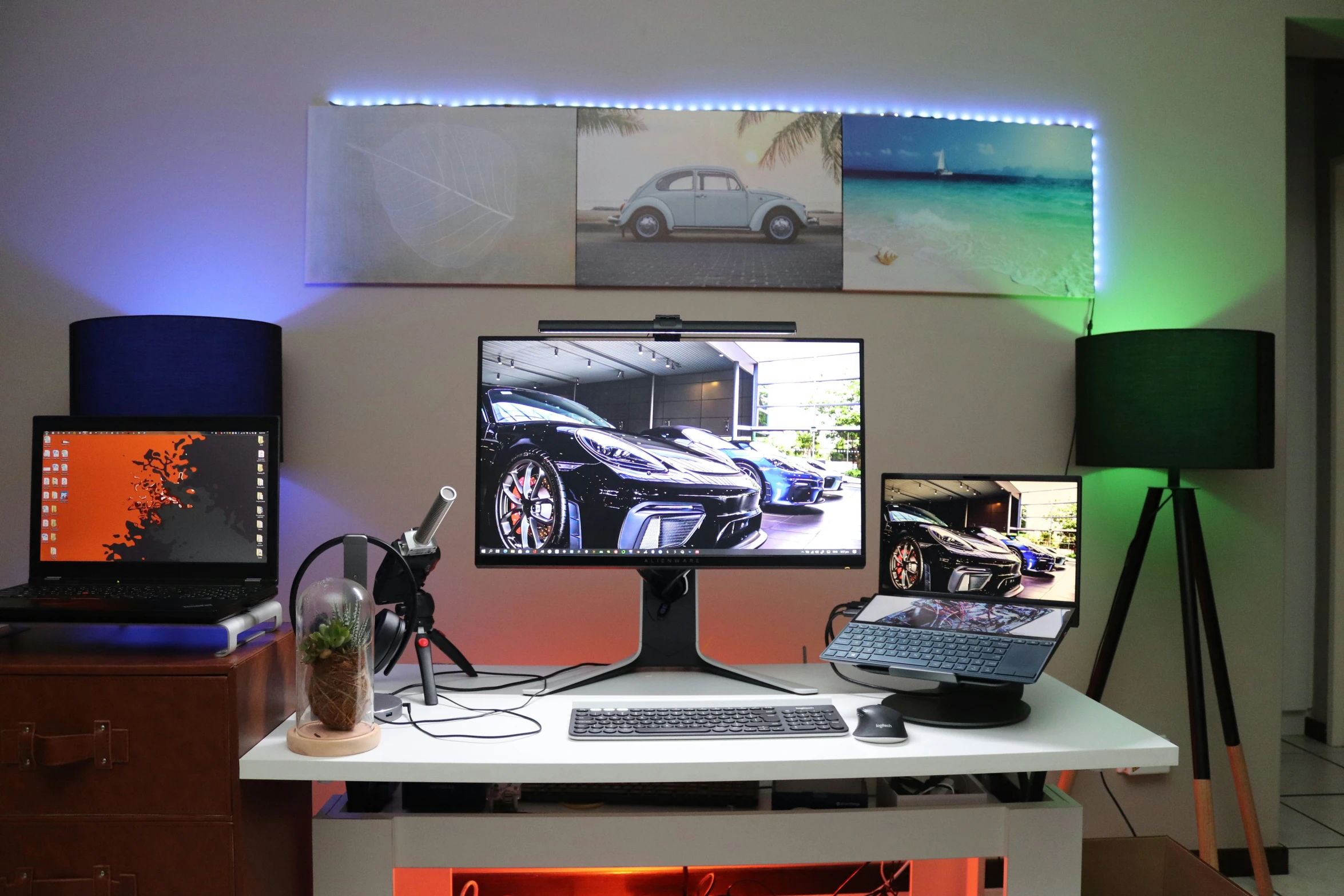 two computers, two monitors and a microphone on a white desk