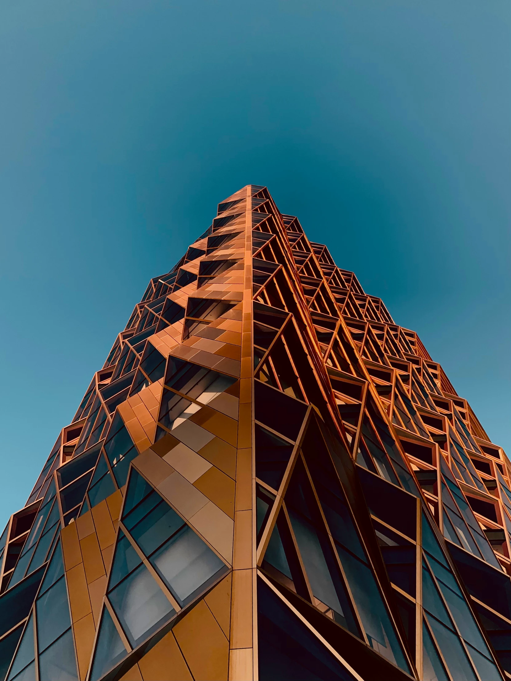 looking up at the top of an ornate glass and steel skyscr