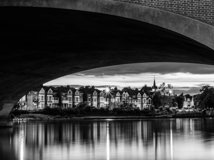 black and white pograph of a river under a bridge