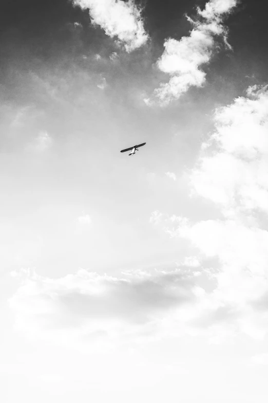 the airplane is flying in the sky with clouds