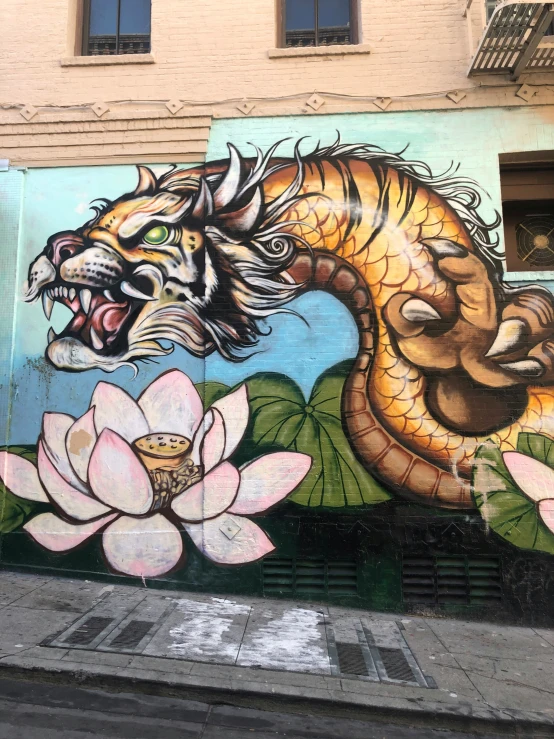 a mural painted on a side wall with a dragon and a flower