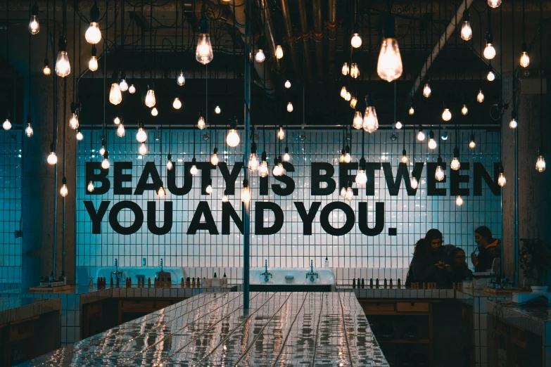 a restaurant decorated with artful lighting bulbs and a quote