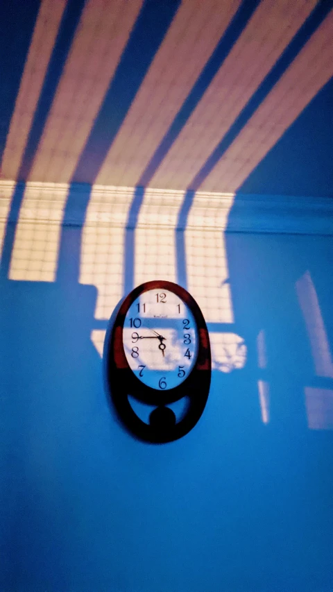 a clock on a wall with light streaming through it