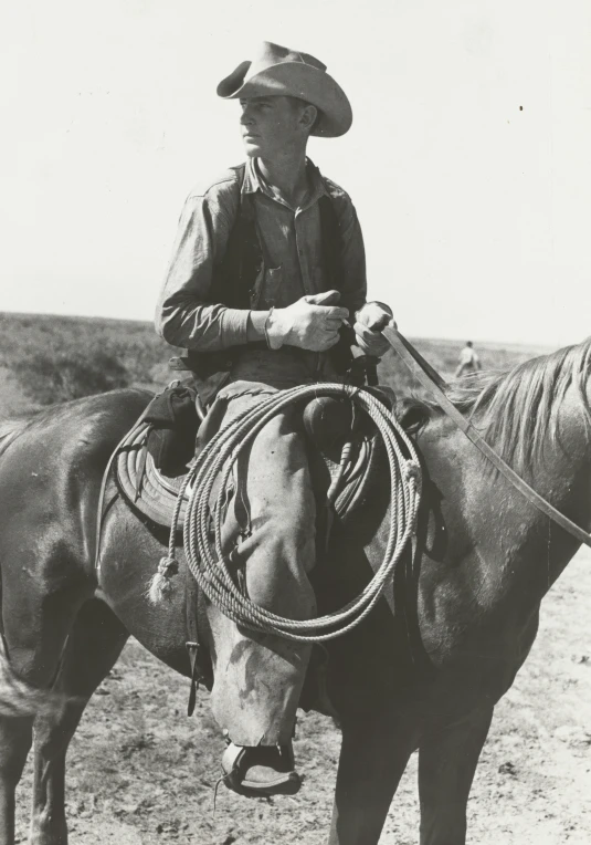 a man with a hat and horse standing in the desert