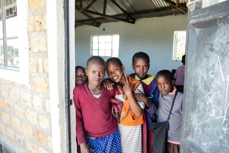 a group of children stand together and smile