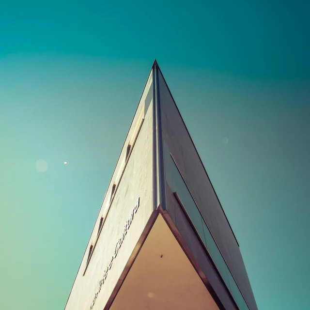 a triangular tower with a blue sky background