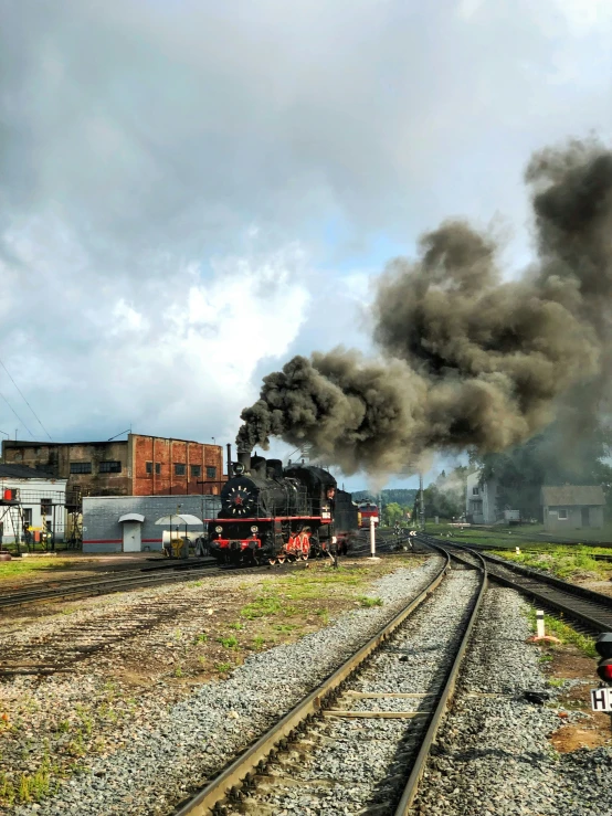 train emitting black smoke coming out of the back of a building