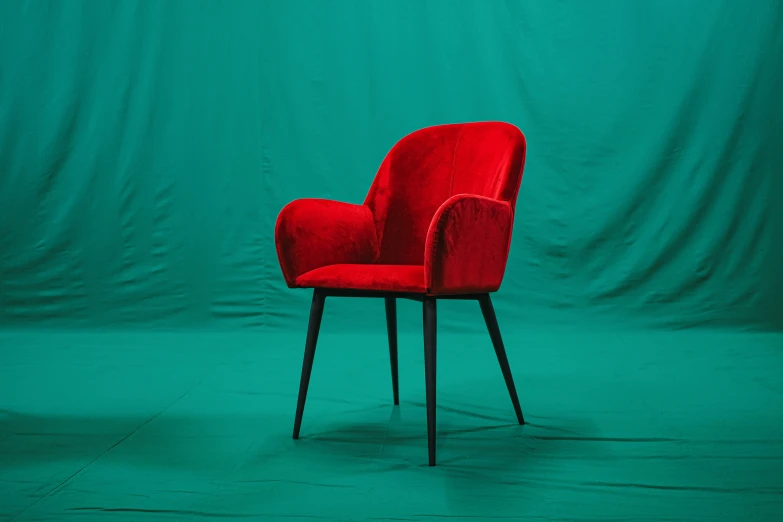 a chair sitting up against a green backdrop