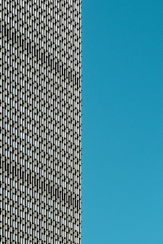 an airplane flying through the blue sky next to tall buildings