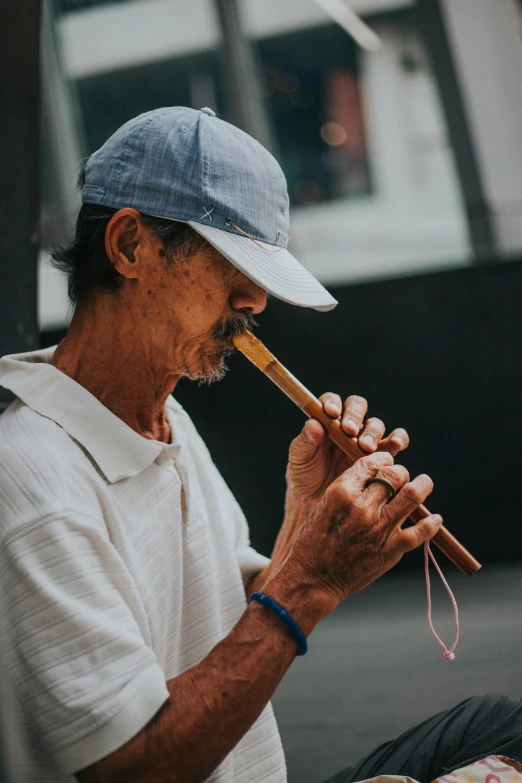 an older man is sitting outside smoking soing