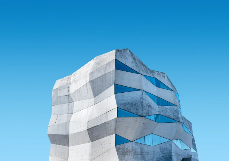 the side of an architectural structure with a blue sky behind it