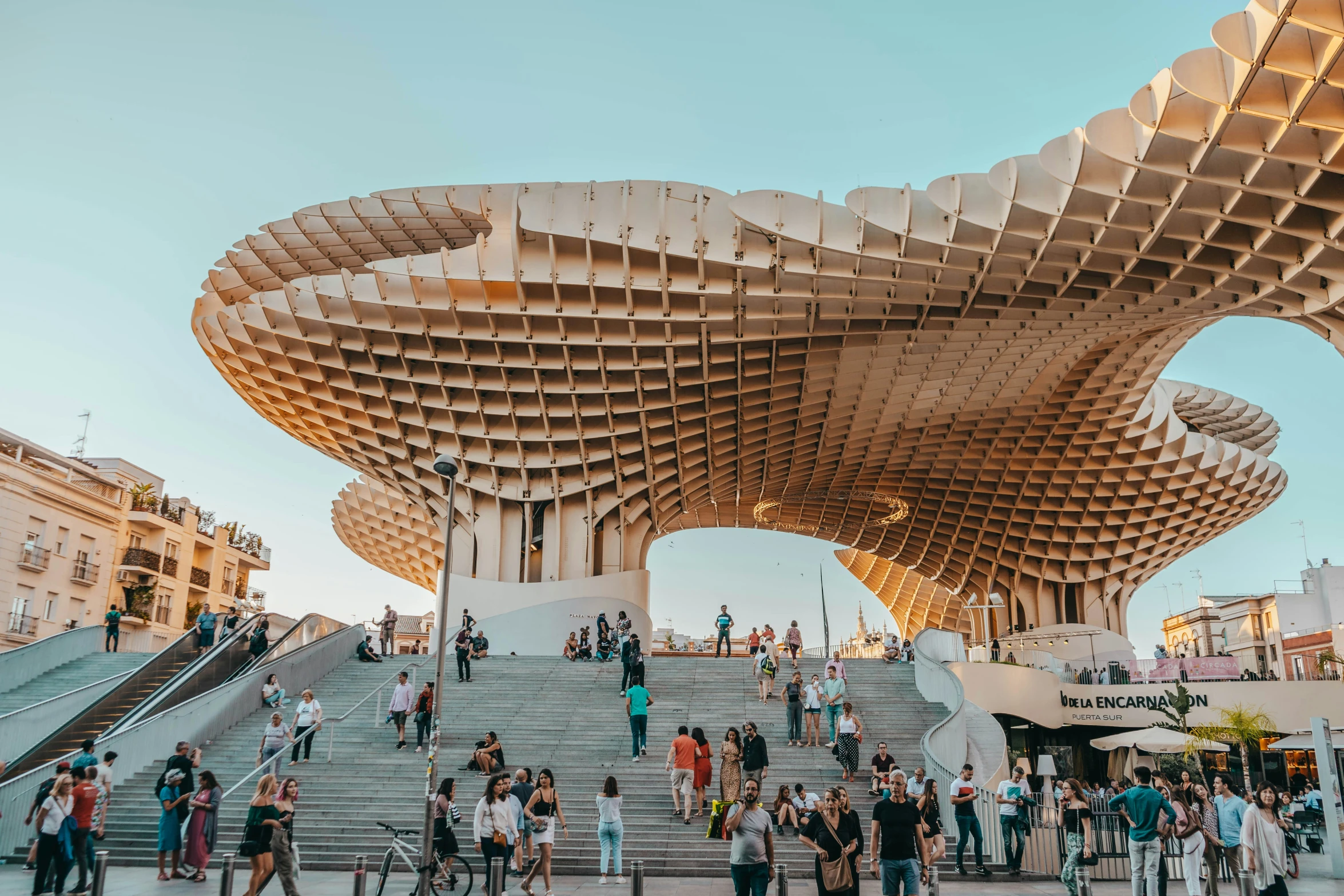 a giant wooden structure with people walking around